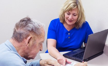 Stock image: A female doctor sitting with an elderly male patient